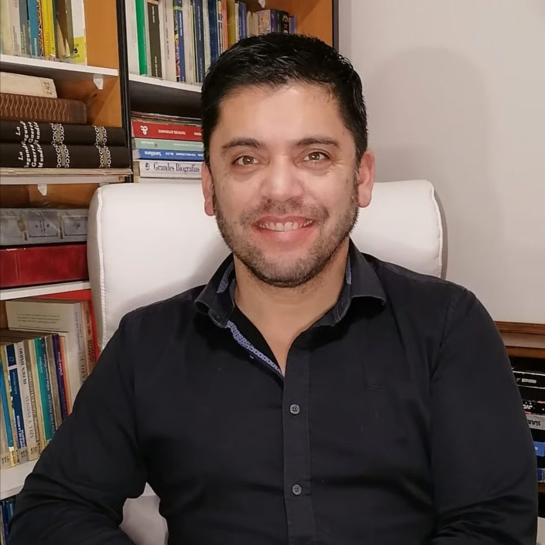 Cristian Moraga Jerez, psicólogo, en su consulta frente a su biblioteca